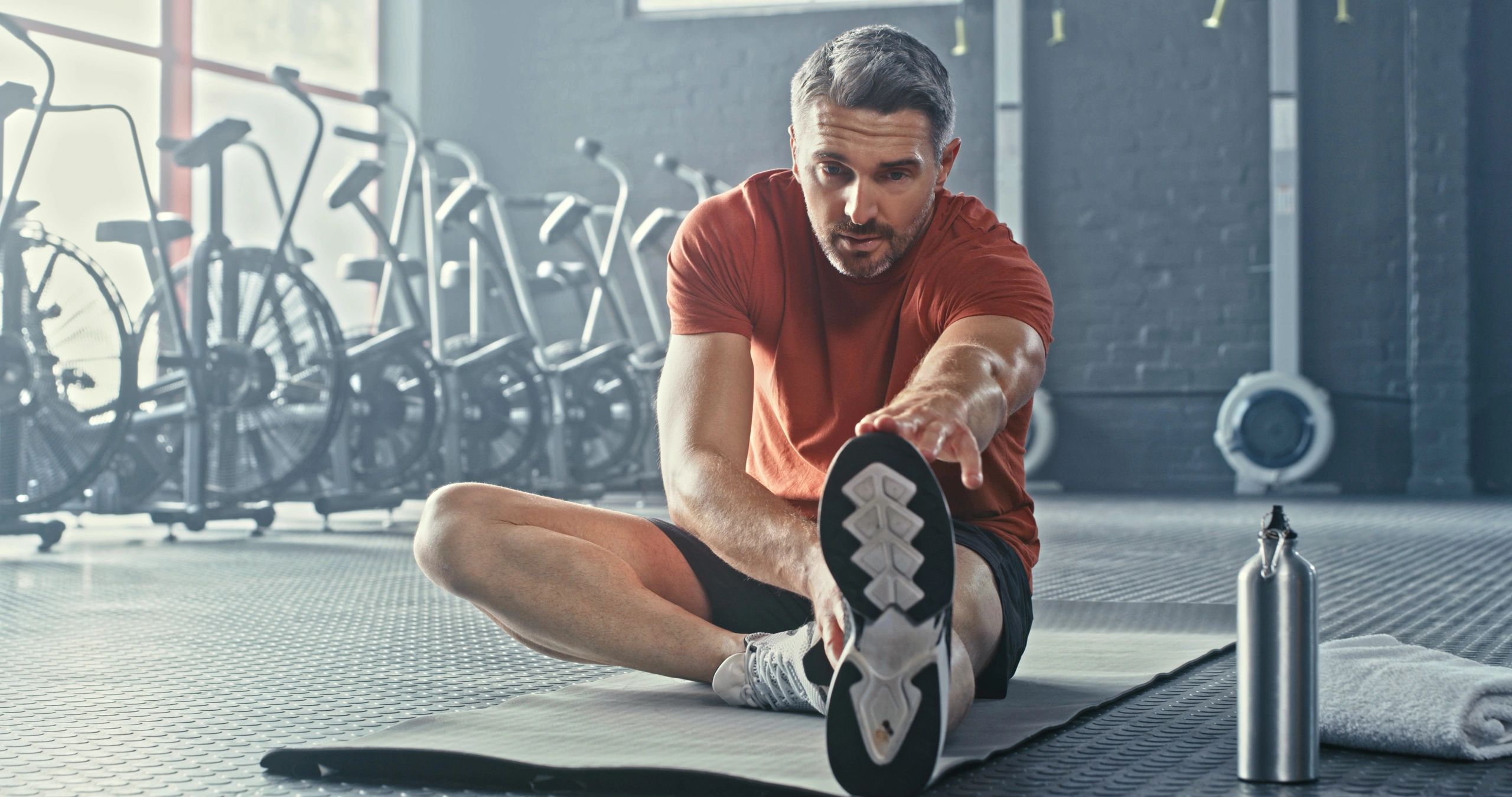 Athlete stretching for recovery after a workout in a gym
