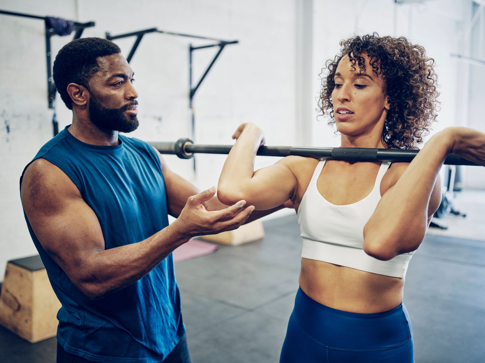 Trainer guiding a client through a functional training exercise