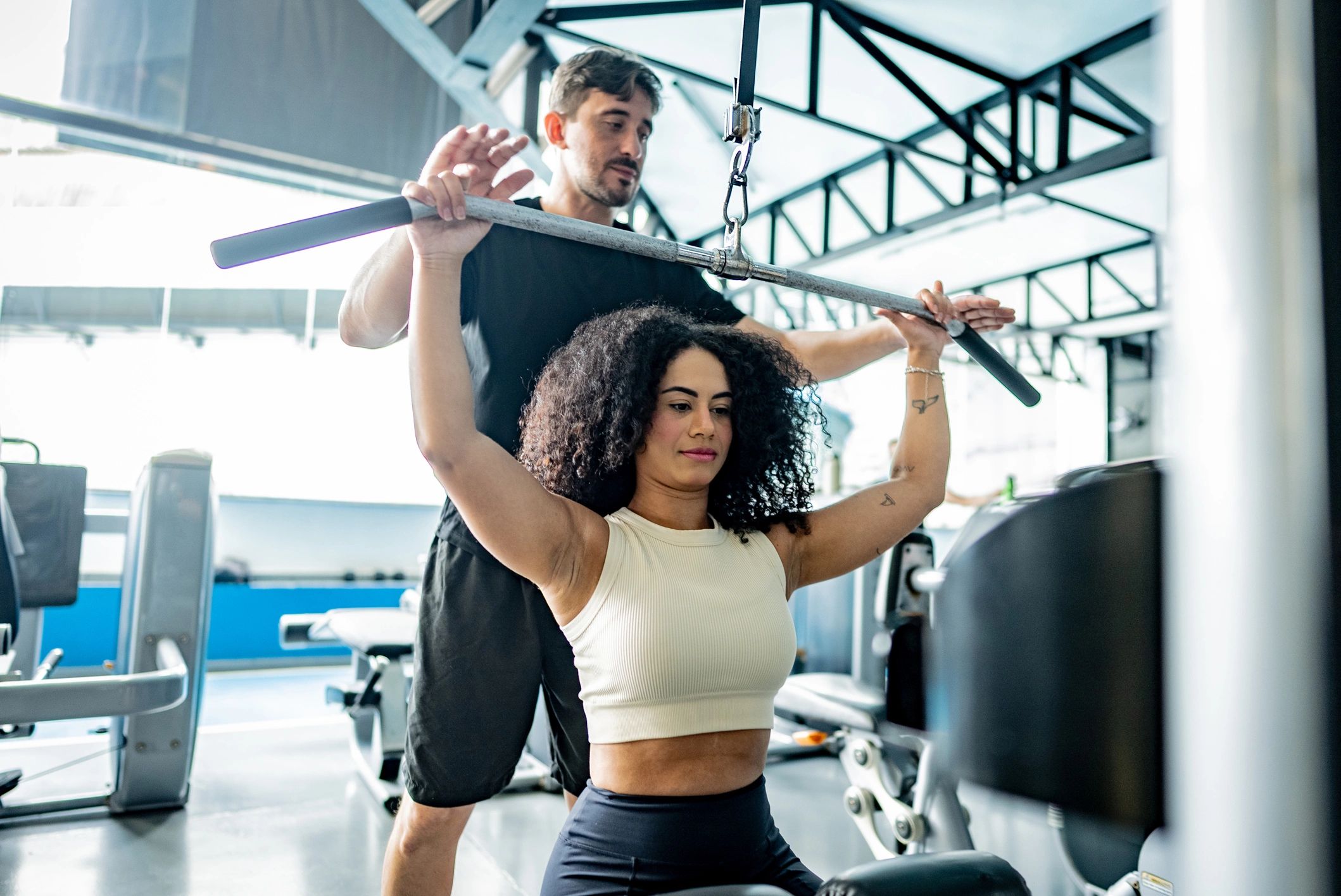 Trainer assisting a client during a strength exercise